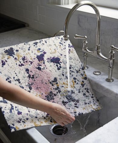 Person rinsing Painter's Palette FLOR carpet tile stained with red wine in the sink. 